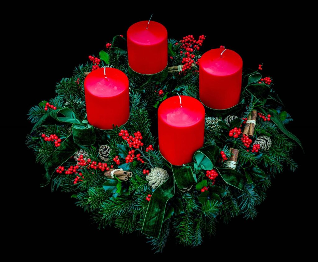 Adventskranz mit Tannengrün und roten Kerzen